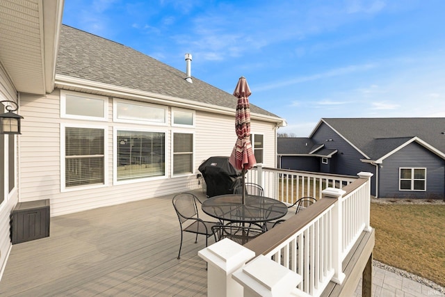 wooden terrace with outdoor dining space and area for grilling