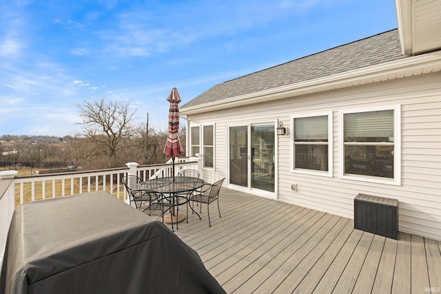 wooden deck featuring a grill and outdoor dining space