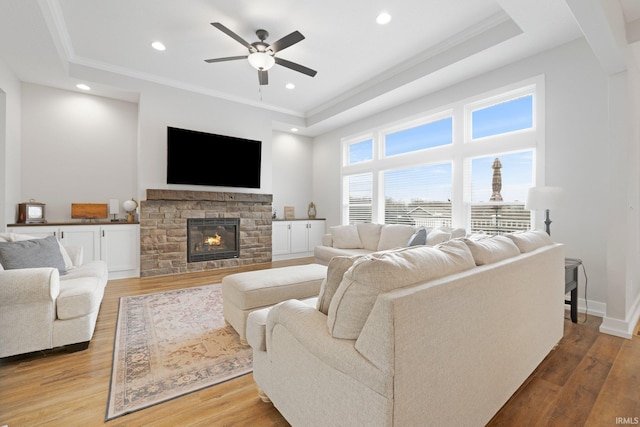 living area with crown molding, recessed lighting, a fireplace, and wood finished floors