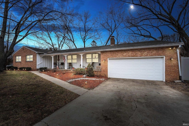 ranch-style house featuring concrete driveway, a chimney, an attached garage, a porch, and brick siding