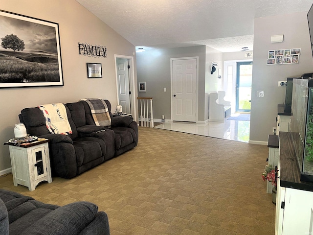 living room with lofted ceiling, a textured ceiling, and baseboards