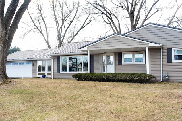 view of front of house with metal roof, a front lawn, and an attached garage