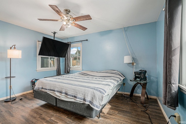 bedroom with a ceiling fan, baseboards, and wood finished floors