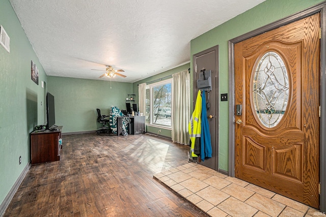 foyer featuring a textured ceiling, wood finished floors, a ceiling fan, and baseboards