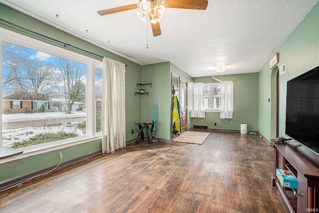 interior space with visible vents, a ceiling fan, a textured ceiling, wood finished floors, and baseboards