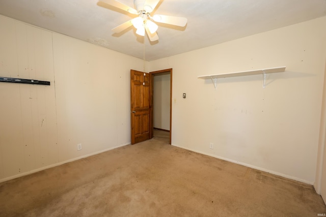 empty room with a ceiling fan and light colored carpet