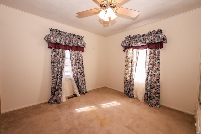 spare room featuring visible vents, carpet flooring, a ceiling fan, and baseboards