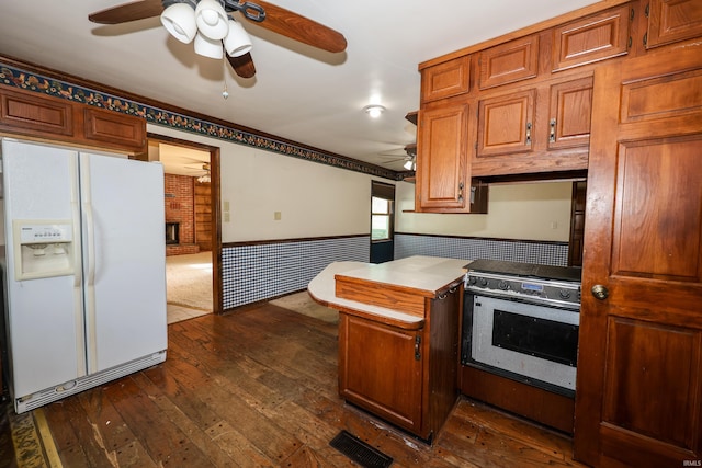 kitchen with visible vents, dark wood-style floors, brown cabinets, stainless steel range with electric stovetop, and white fridge with ice dispenser