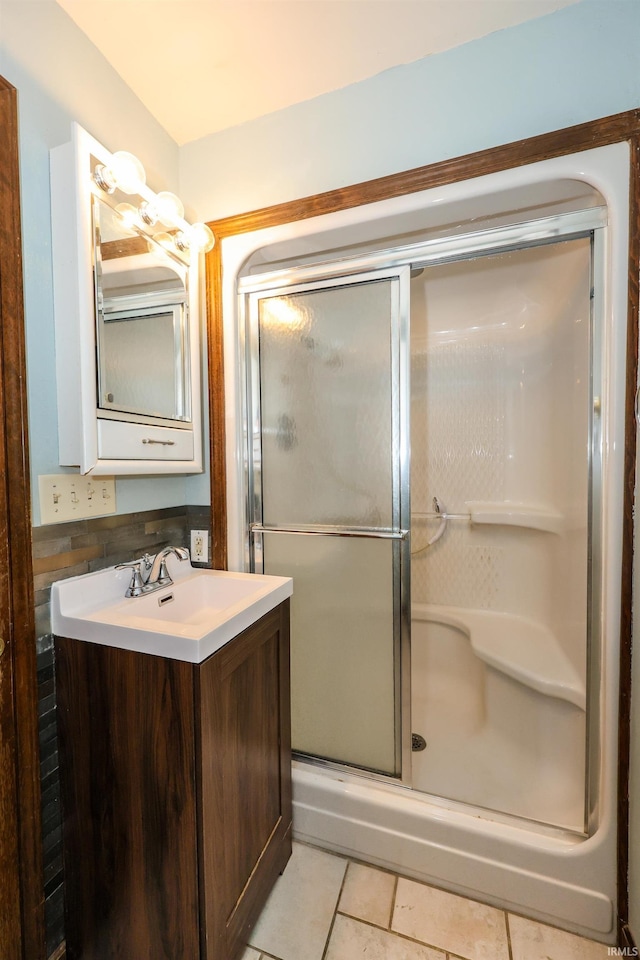 full bath featuring a shower stall, vanity, and tile patterned floors