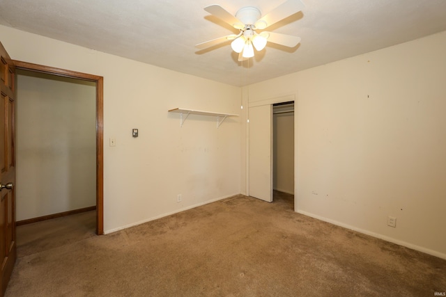 unfurnished bedroom with carpet floors, a ceiling fan, baseboards, and a closet