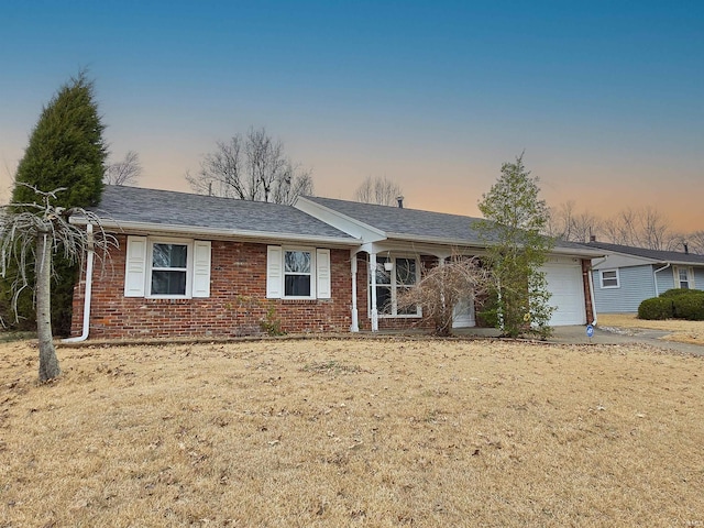 single story home with a garage, brick siding, and roof with shingles