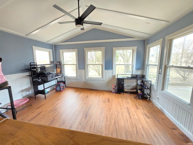 interior space with vaulted ceiling with beams, a wainscoted wall, ceiling fan, and wood finished floors