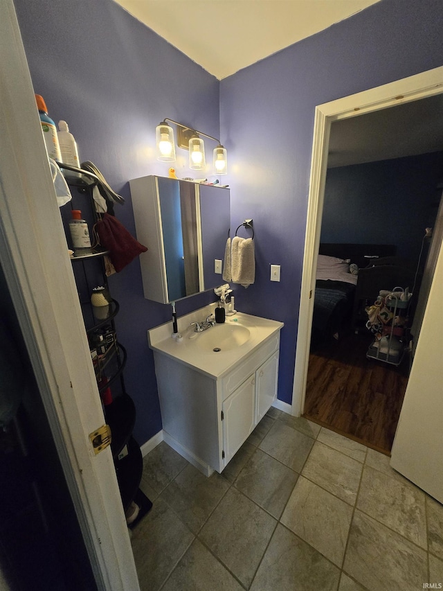 bathroom with vanity, baseboards, and tile patterned floors