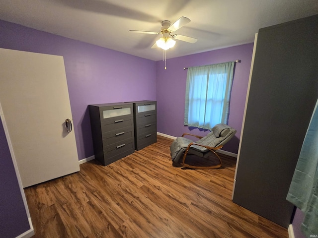 bedroom with dark wood-style floors, ceiling fan, and baseboards