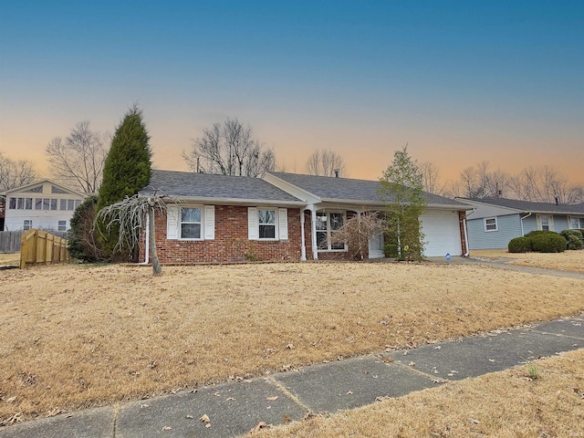 ranch-style home featuring a garage, driveway, fence, and brick siding