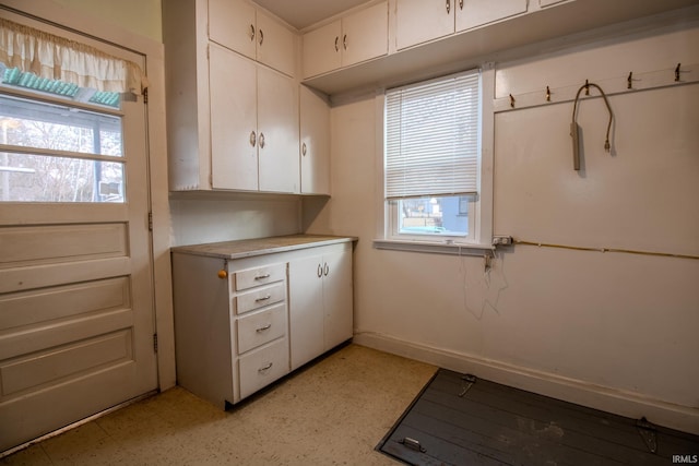 kitchen with baseboards, white cabinetry, and light countertops