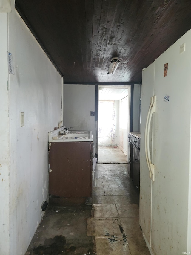 kitchen with freestanding refrigerator, wooden ceiling, and light countertops