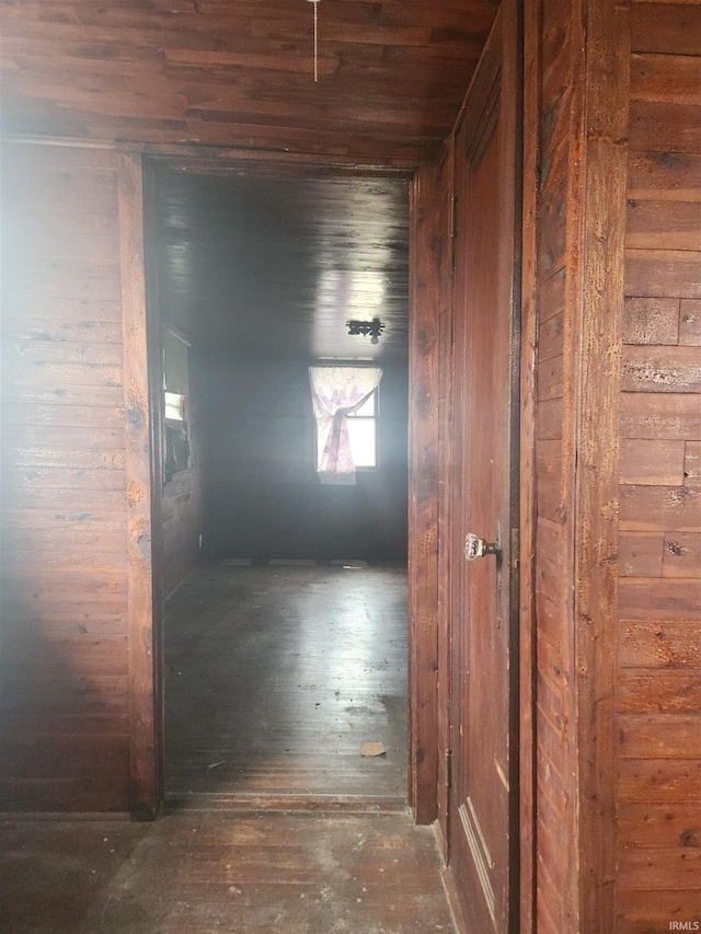 hallway with hardwood / wood-style floors, wooden ceiling, and wooden walls