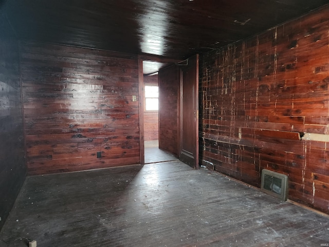 empty room with wood walls and wood finished floors