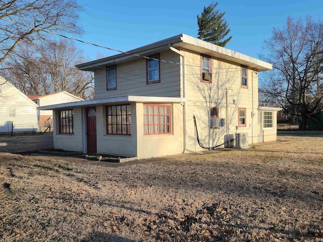 rear view of house featuring cooling unit and brick siding