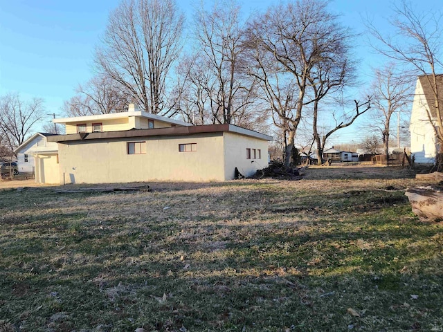 view of home's exterior featuring a yard, a chimney, and stucco siding