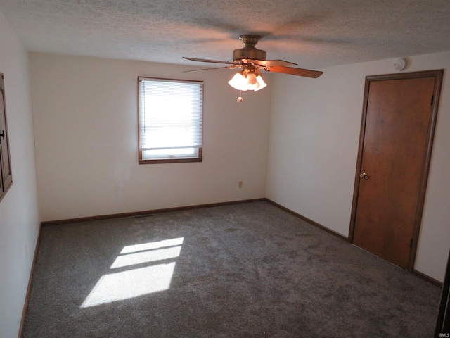 carpeted spare room featuring baseboards and a textured ceiling