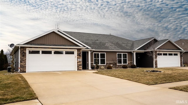 craftsman-style home with driveway, stone siding, an attached garage, a front lawn, and board and batten siding