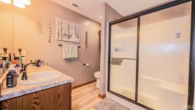 full bathroom featuring toilet, a sink, visible vents, a shower stall, and double vanity