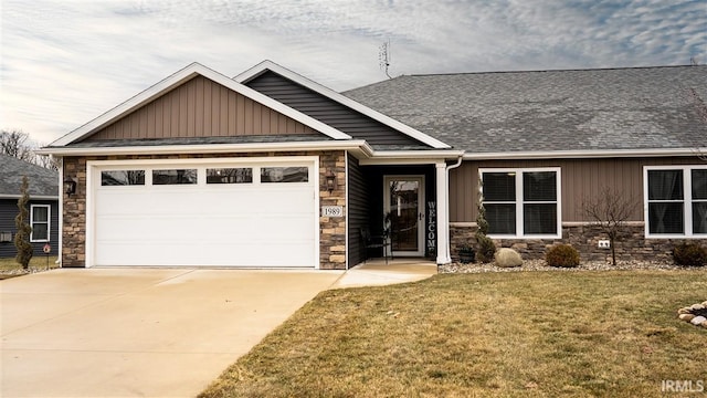 craftsman inspired home featuring a garage, driveway, a front lawn, and board and batten siding