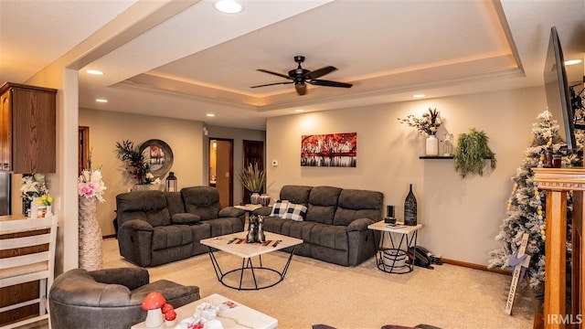 carpeted living area featuring baseboards, a raised ceiling, a ceiling fan, and recessed lighting