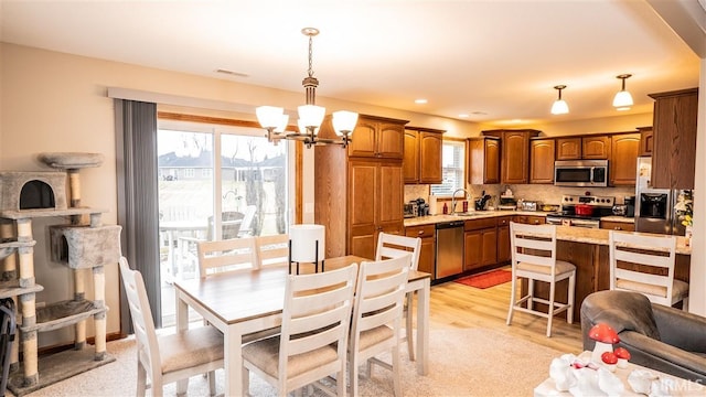 dining space featuring a chandelier, visible vents, and light wood-style floors