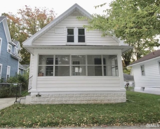 view of side of home featuring a sunroom and a yard