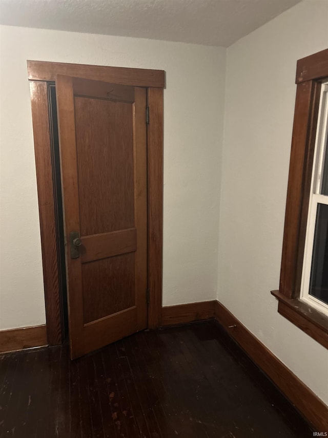 unfurnished room with hardwood / wood-style flooring and baseboards