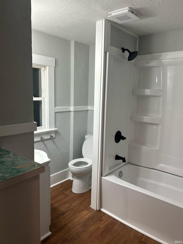 bathroom featuring a textured wall, toilet, a textured ceiling, vanity, and wood finished floors