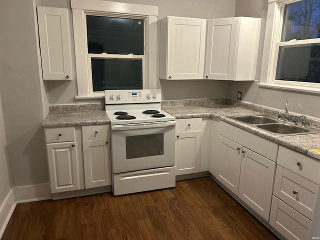 kitchen with dark wood-type flooring, a sink, white electric range oven, and white cabinetry