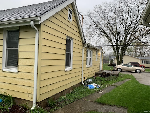 view of side of home with a shingled roof