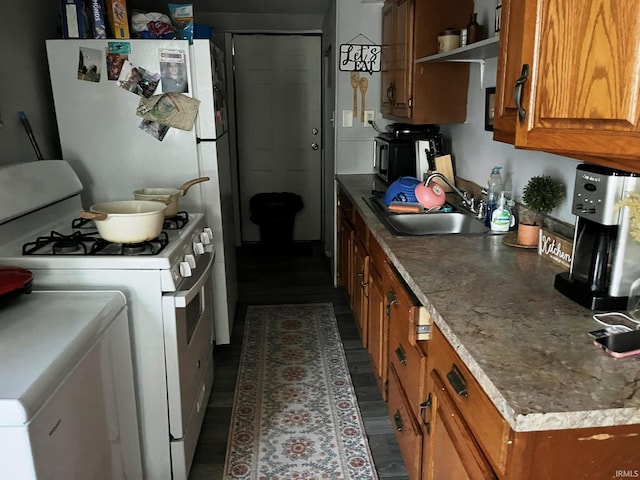 kitchen featuring white appliances, a sink, brown cabinets, open shelves, and washer / dryer