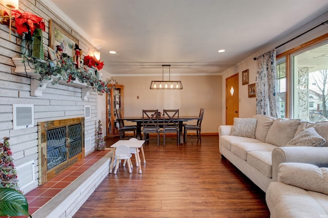 living area featuring recessed lighting, visible vents, ornamental molding, wood finished floors, and a tile fireplace