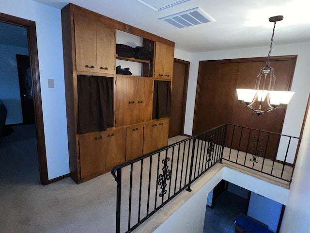 stairs featuring baseboards, visible vents, carpet flooring, and an inviting chandelier