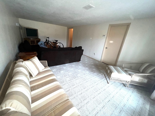 carpeted living area with visible vents and a textured ceiling