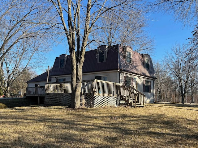 view of side of home with metal roof, a deck, a lawn, and a gambrel roof