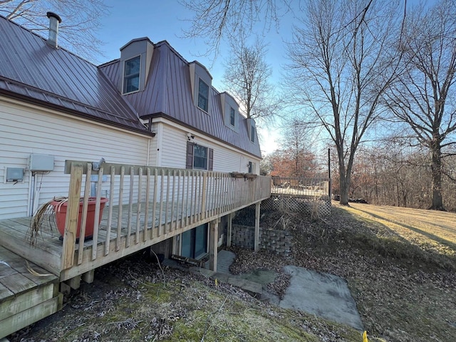 view of side of property featuring metal roof and a deck