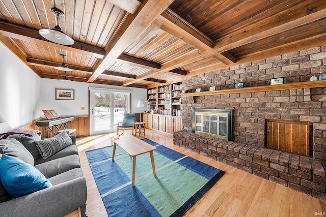 living room with wood ceiling, a fireplace, beam ceiling, and wood finished floors