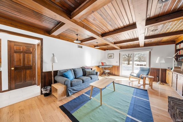 living area with wooden ceiling, light wood-style floors, and a wainscoted wall