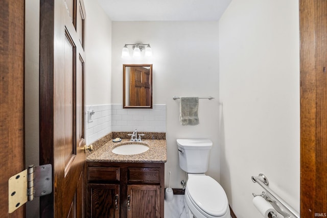 bathroom featuring vanity, toilet, and decorative backsplash