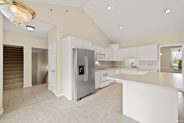 kitchen with white appliances, a center island, light countertops, white cabinetry, and a sink