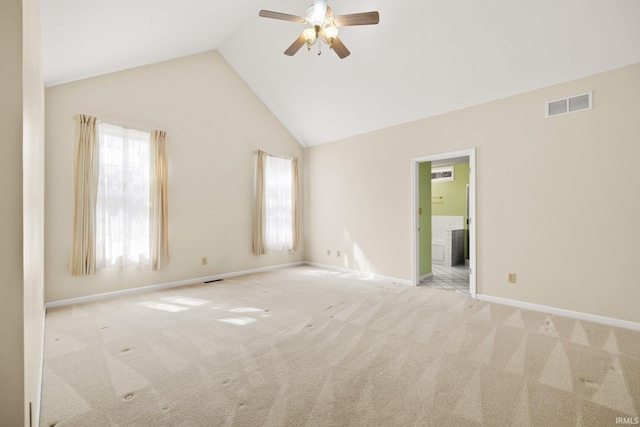 unfurnished room with baseboards, visible vents, a ceiling fan, light colored carpet, and high vaulted ceiling