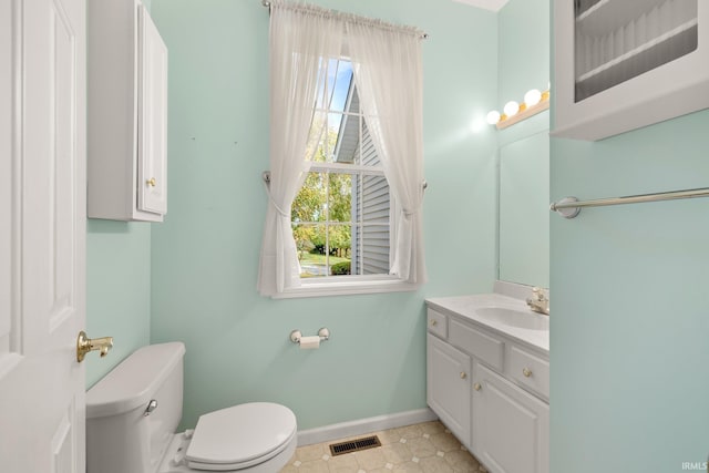 bathroom with toilet, visible vents, vanity, baseboards, and tile patterned floors