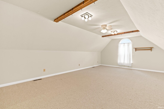 bonus room featuring lofted ceiling, light colored carpet, visible vents, a textured ceiling, and baseboards