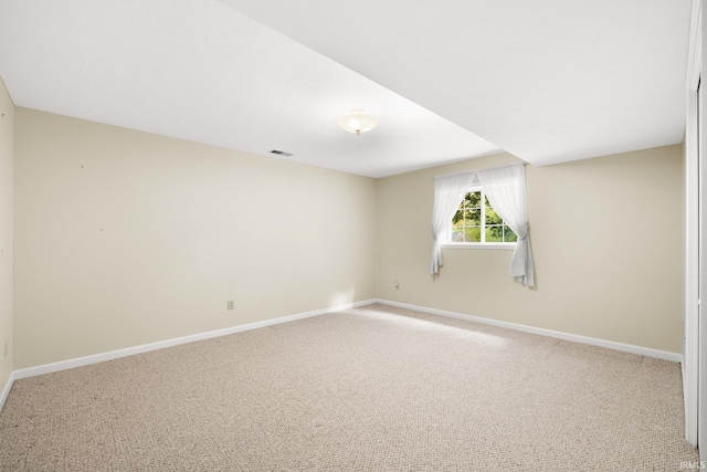 empty room featuring carpet, visible vents, and baseboards